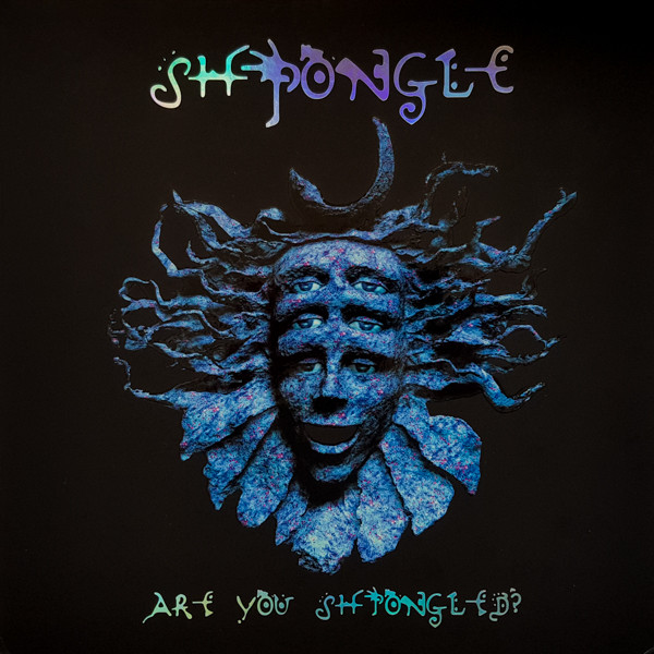 Cover of Are You Shpongled? (1998): the blue Shpongle mask sculpture with three pairs of eyes, wavy hair, and a crescent moon, on black
