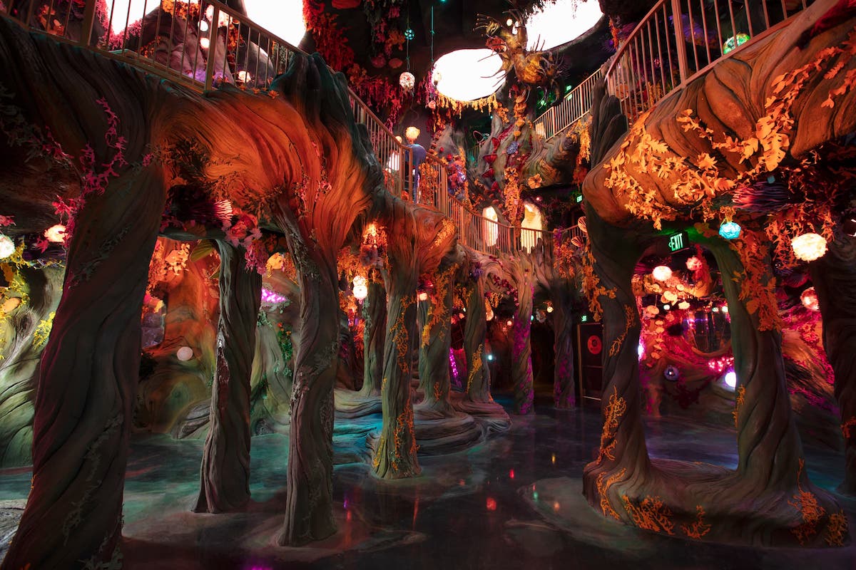 Exhibition interior at Meow Wolf’s Convergence Station: tree-like forms, hanging lights and elevated walkways
